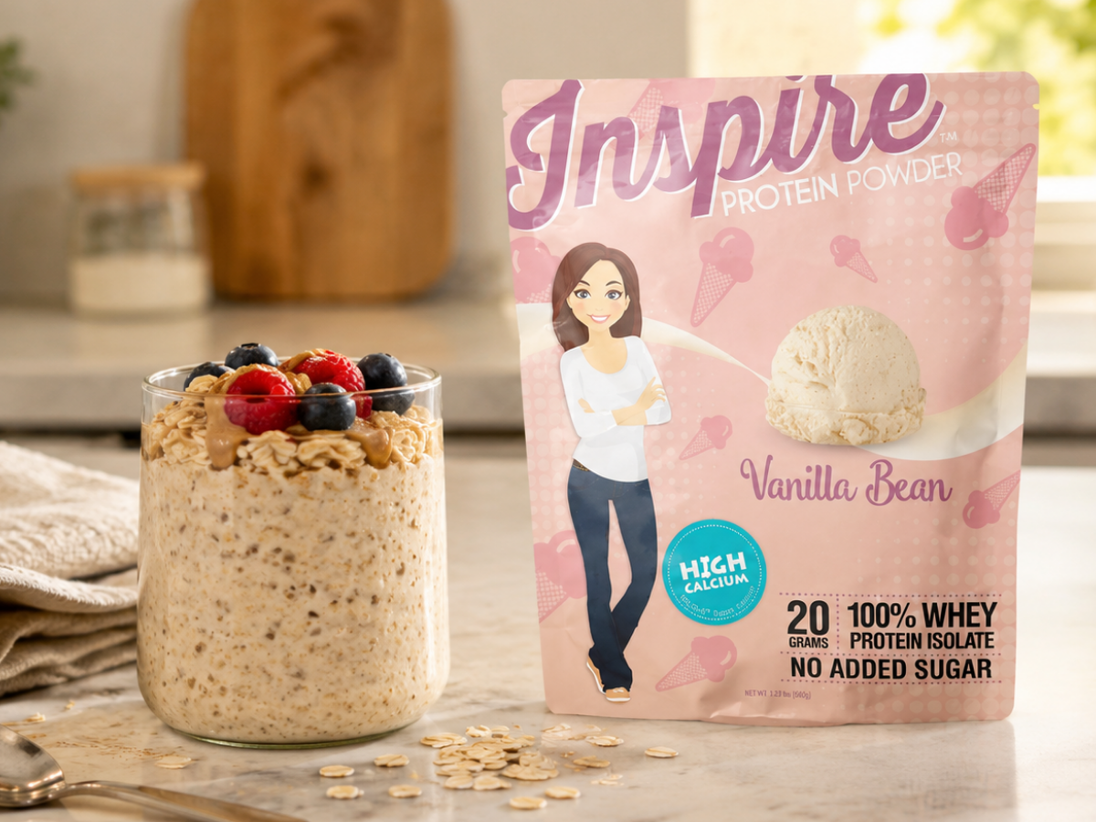 Creamy overnight protein oats topped with berries and nut butter beside Inspire Vanilla Bean Protein Powder on a bright kitchen counter.