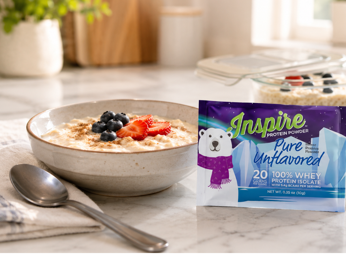 Small protein-focused meal beside an Inspire Pure Unflavored Protein Powder packet, with water and a meal container in a bright kitchen.