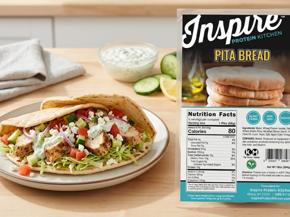 Loaded chicken pita wrap made with Inspire Protein Kitchen Pita, shown sliced with fresh vegetables and product packaging beside it.