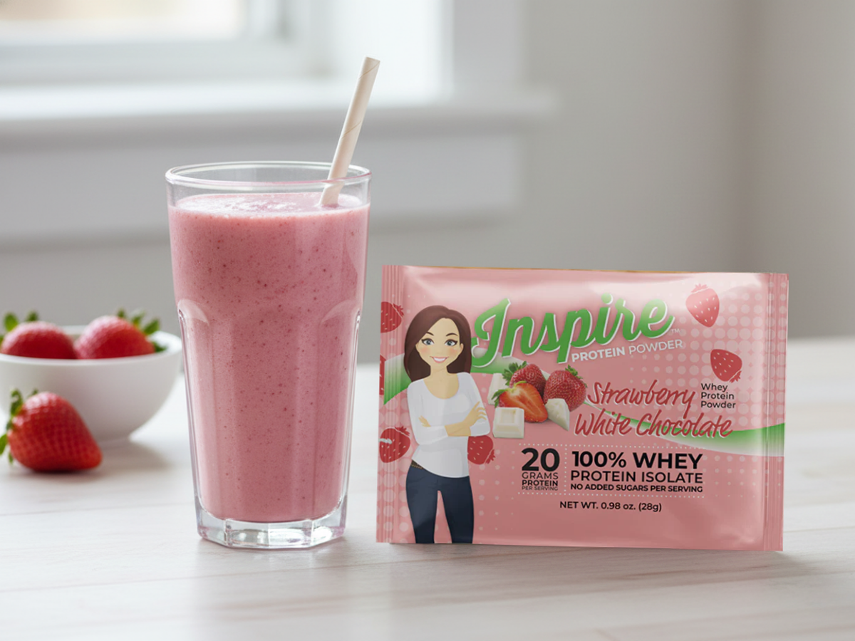 High-protein spring breakfast smoothie made with strawberries, served in a clear glass beside Inspire Strawberry White Chocolate Protein Powder on a bright table.