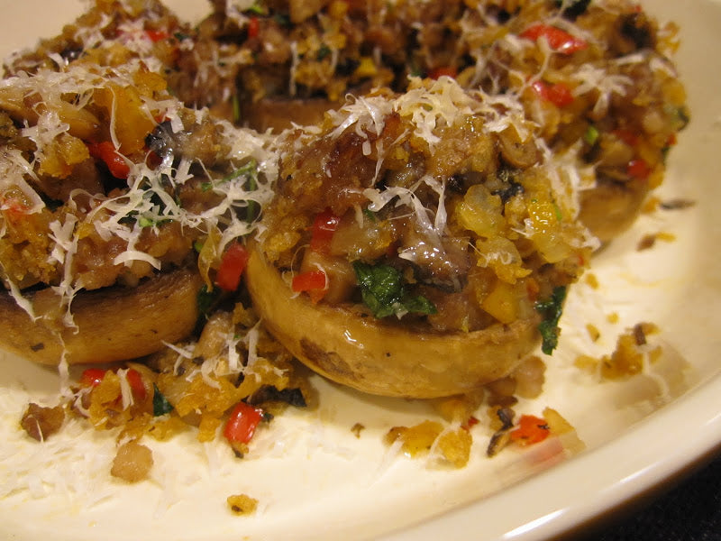 Stuffed mushrooms filled with a sautéed veggie and breadcrumb mixture, topped with grated cheese.