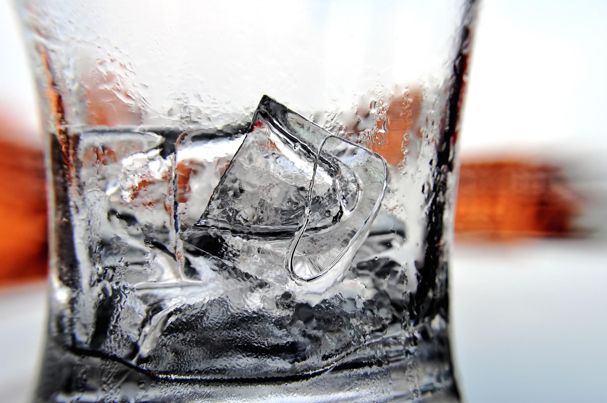 Close-up of melting ice cubes inside a clear glass.