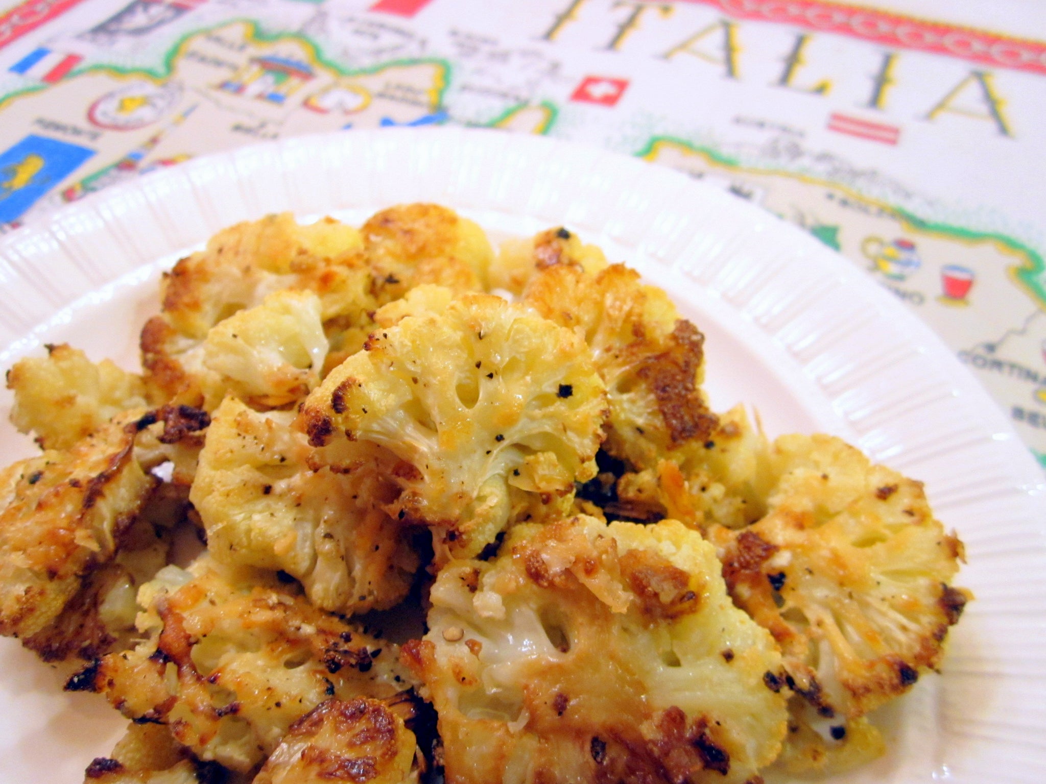 Plate of roasted cauliflower florets with a golden, crispy coating.