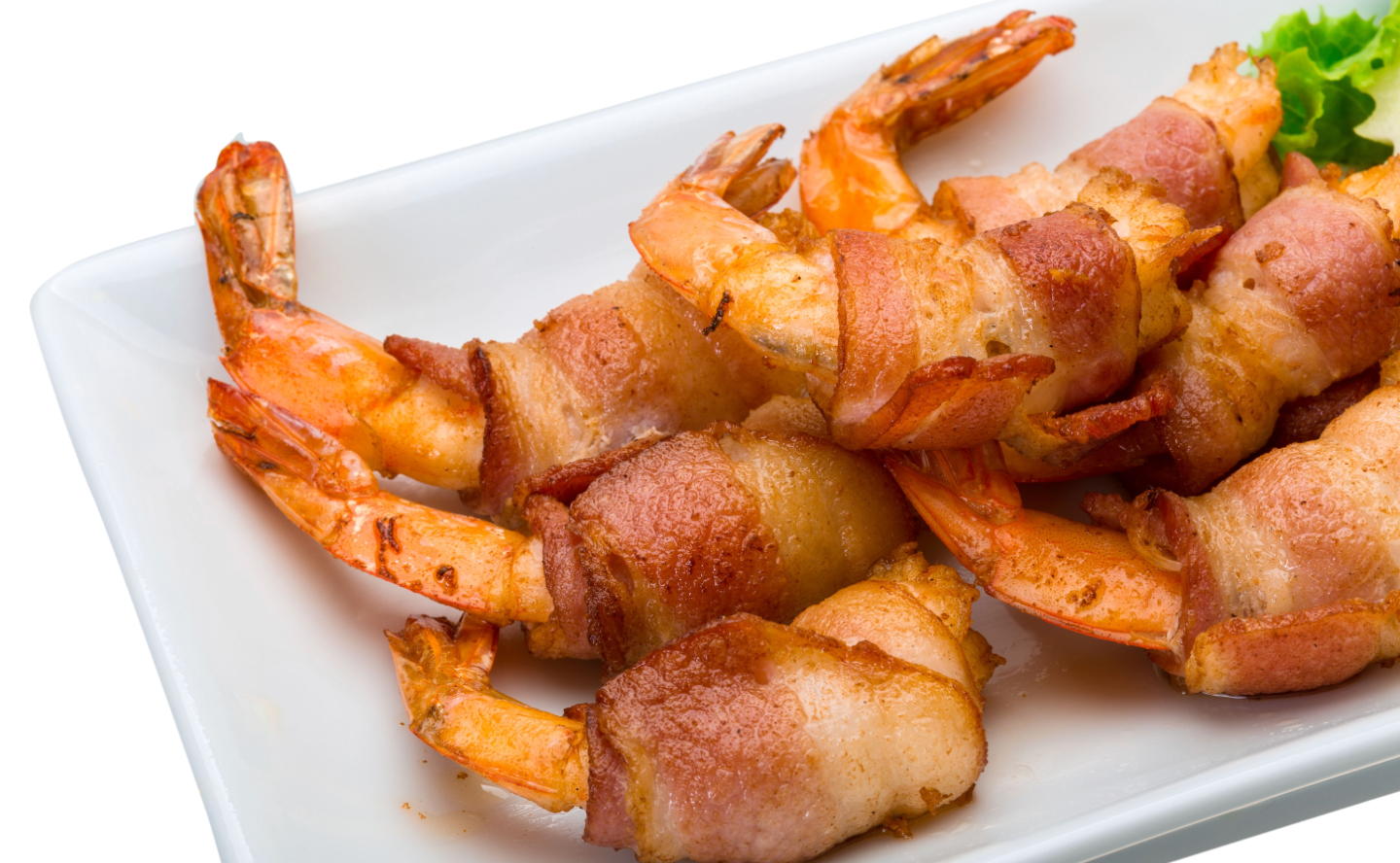 Bacon-wrapped shrimp arranged on a white plate.