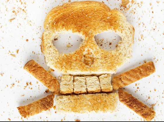 Toast pieces arranged to form a skull and crossbones with crumbs scattered around.