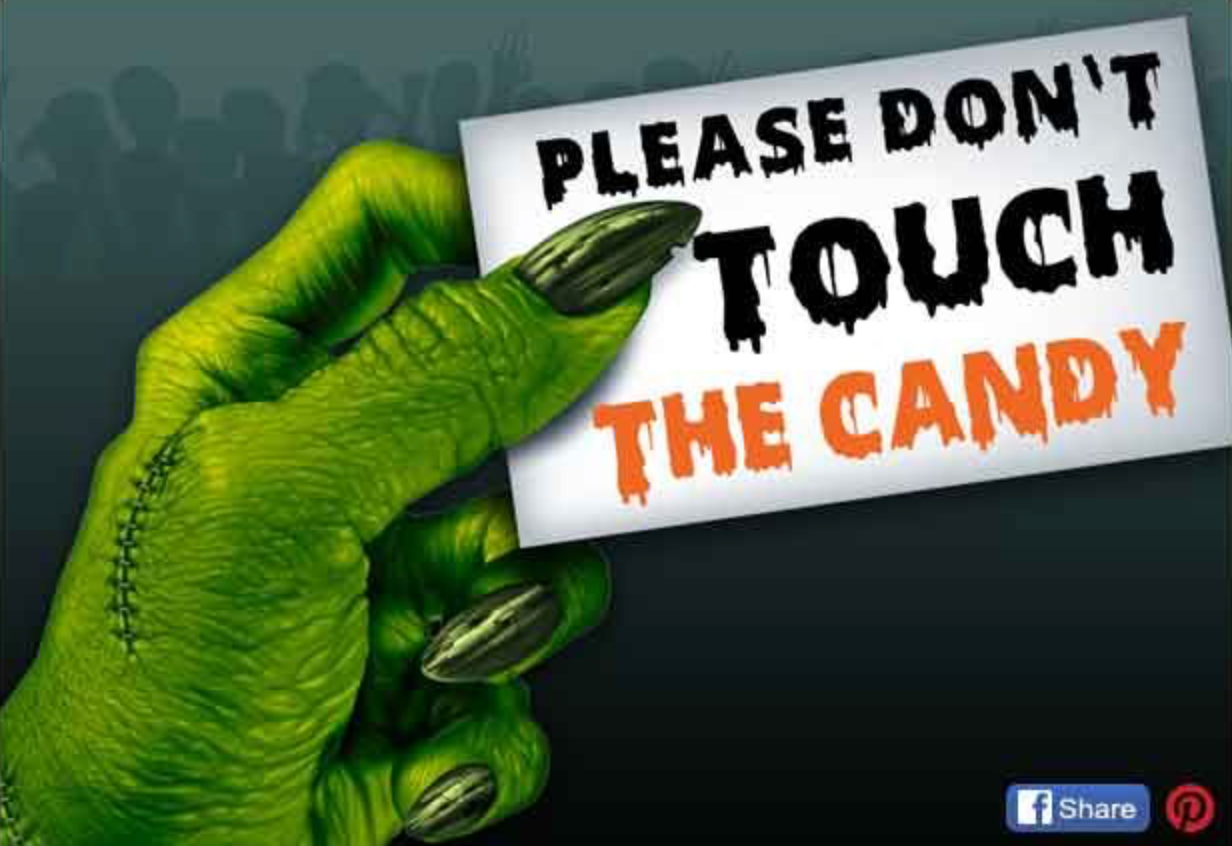 Green monster hand holding a sign that says “Please Don’t Touch the Candy,” written in spooky black and orange lettering.