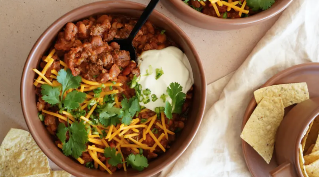  bowl of Inspire Tex-Mex high-protein chili topped with Greek yogurt and cheese