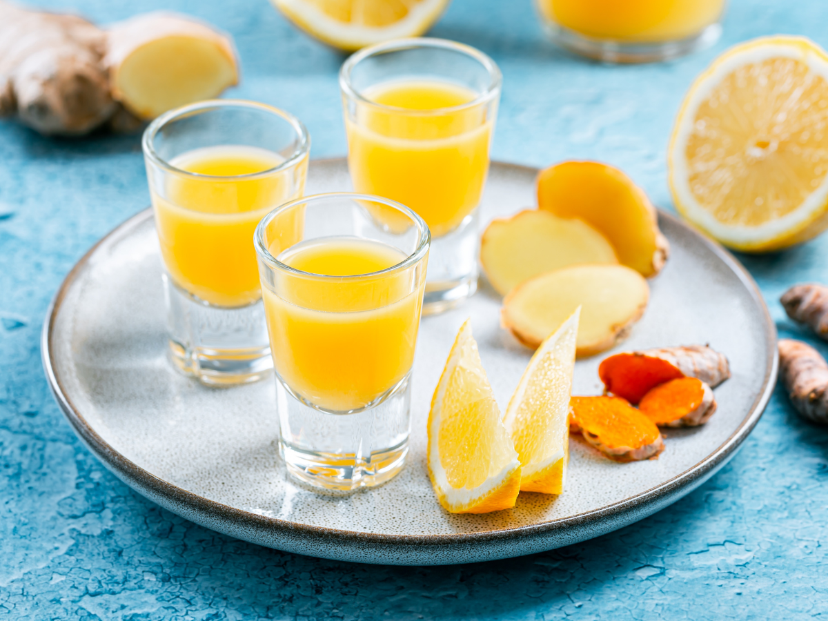 Lemon ginger protein shot with fresh ginger slices, lemon wedges, and unflavored protein powder