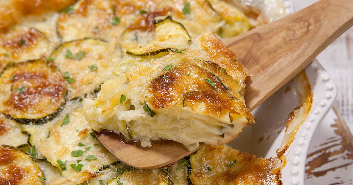 Slice of creamy baked zucchini gratin with golden cheese topping lifted from a casserole dish.