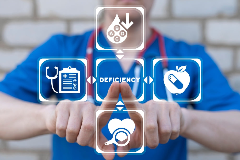 A healthcare professional in a blue shirt points at icons representing health, deficiency, nutrition, and medical care, set against a light brick background.