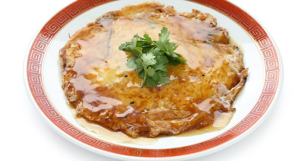 Golden omelette covered in glossy brown sauce and topped with fresh cilantro.