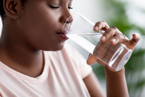 a light clear drink in a clear glass showing hydration and the glow that comes