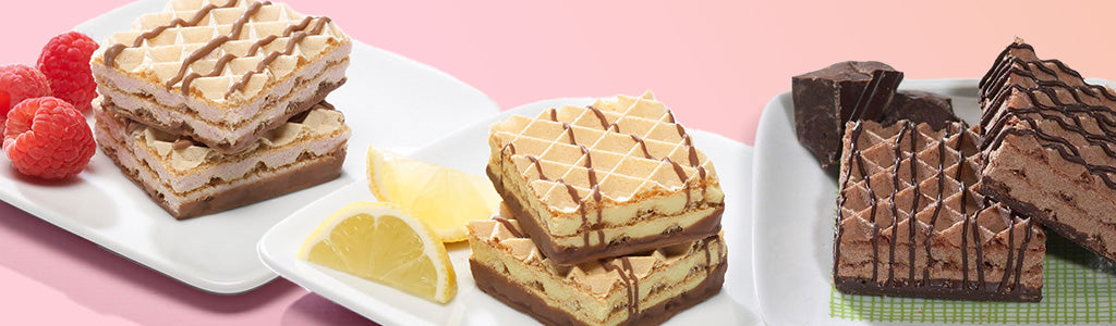 Three types of layered wafers are displayed on white plates, featuring flavors like chocolate, lemon, and a creamy filling, with fresh raspberries and lemon slices as garnish against a soft pink background.