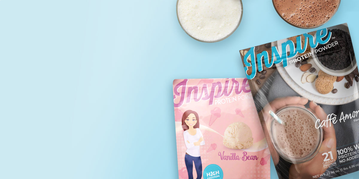 Pink and brown protein powder packages labeled Vanilla Bean and Caffè Amore sit beside bowls of creamy and chocolate-colored drinks on a light blue background.