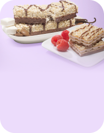 Two plates of dessert feature chocolate-coated wafer bars and layered cream squares, garnished with fresh raspberries, set against a soft purple background.